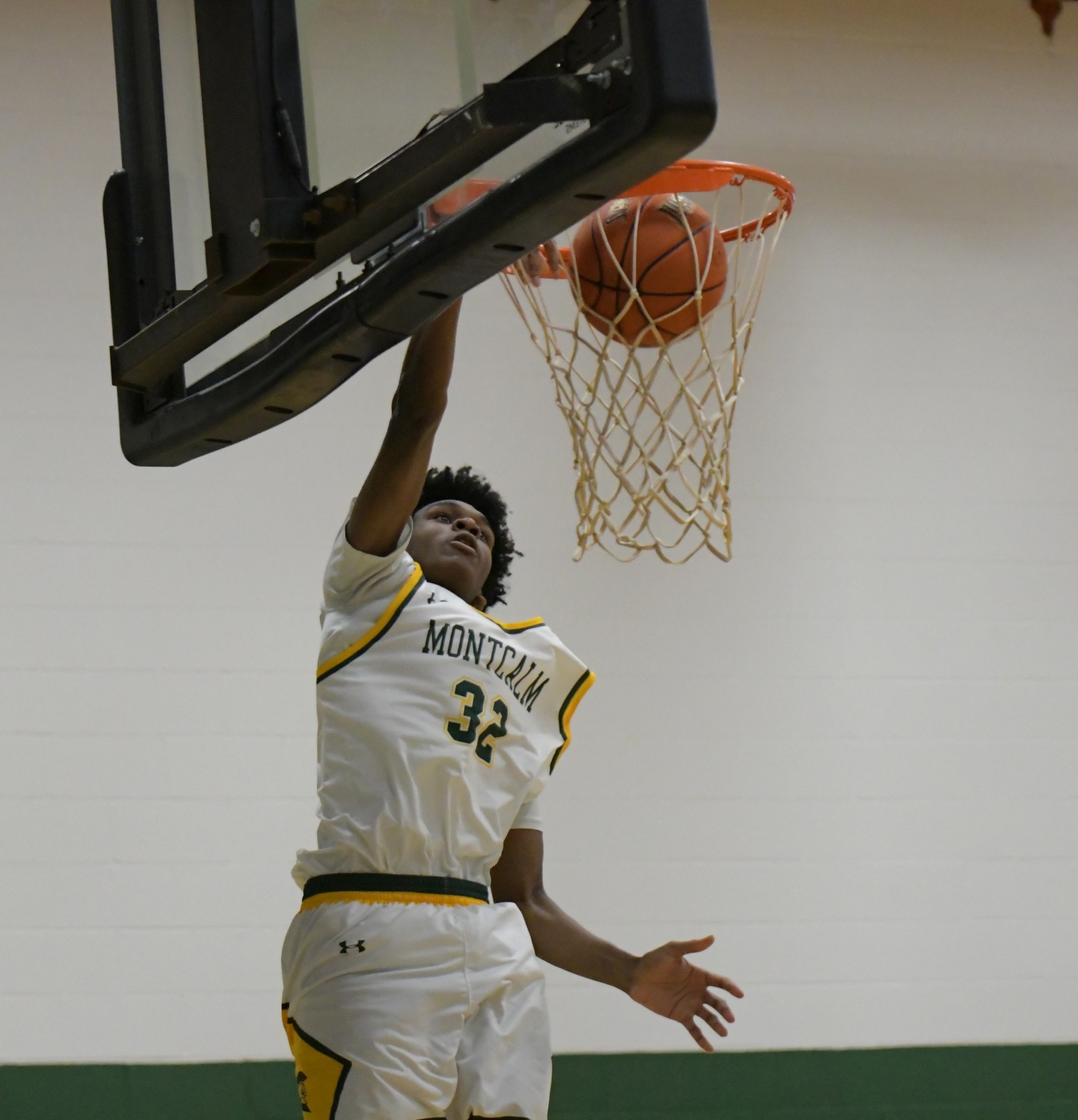 MCC men's basketball player dunking the ball during a game. He is wearing uniform number 32.
