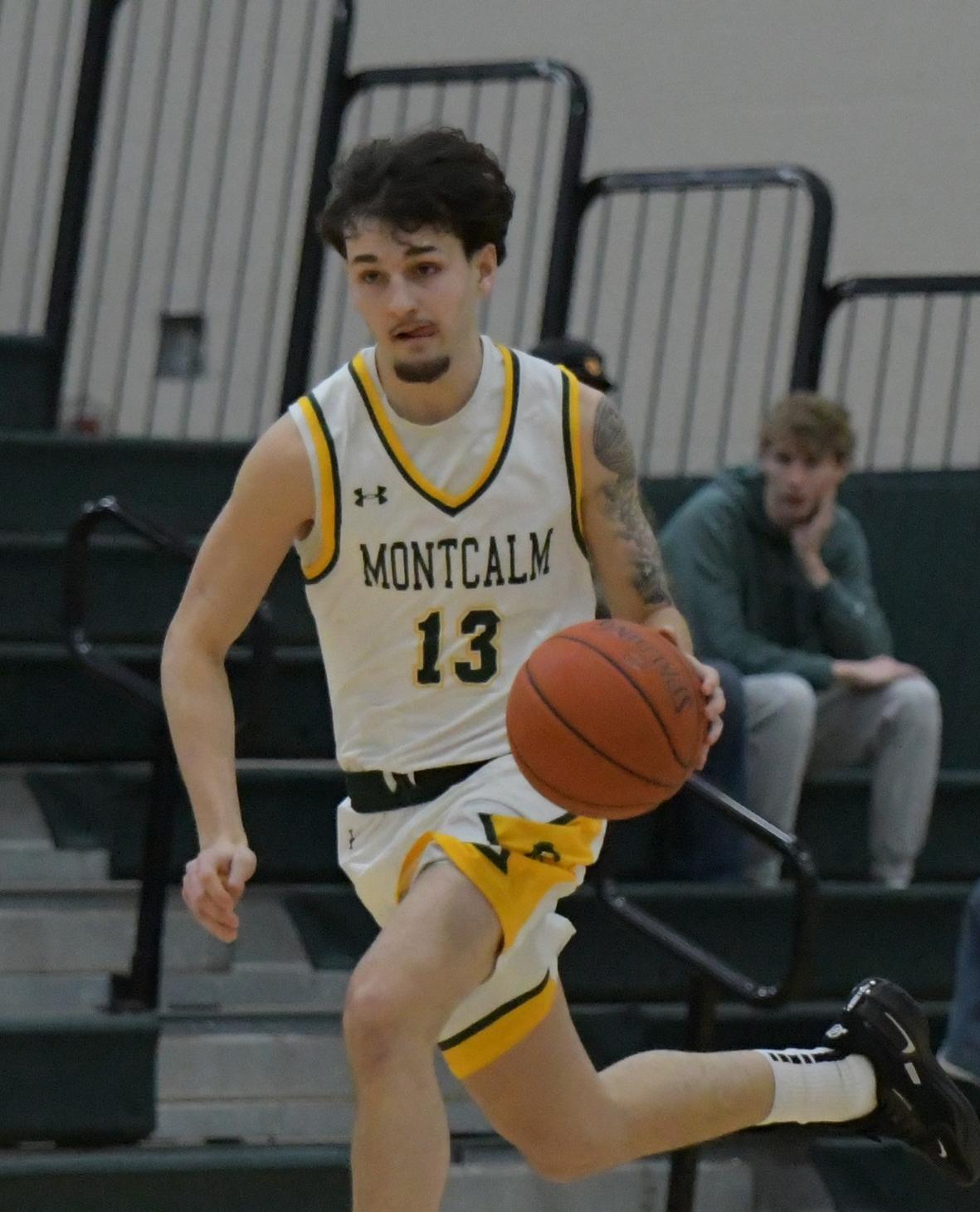 Men's basketball player runing and dribbling the ball down the court.