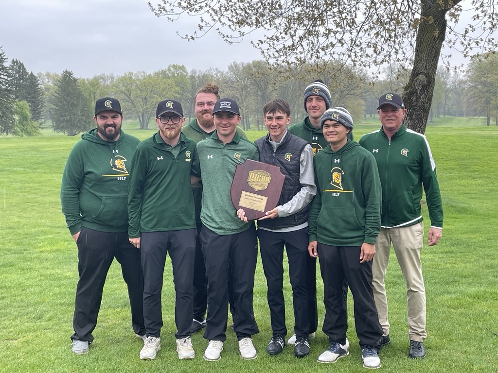 2025 men's golf team standing outside holding their regional championship plaque.