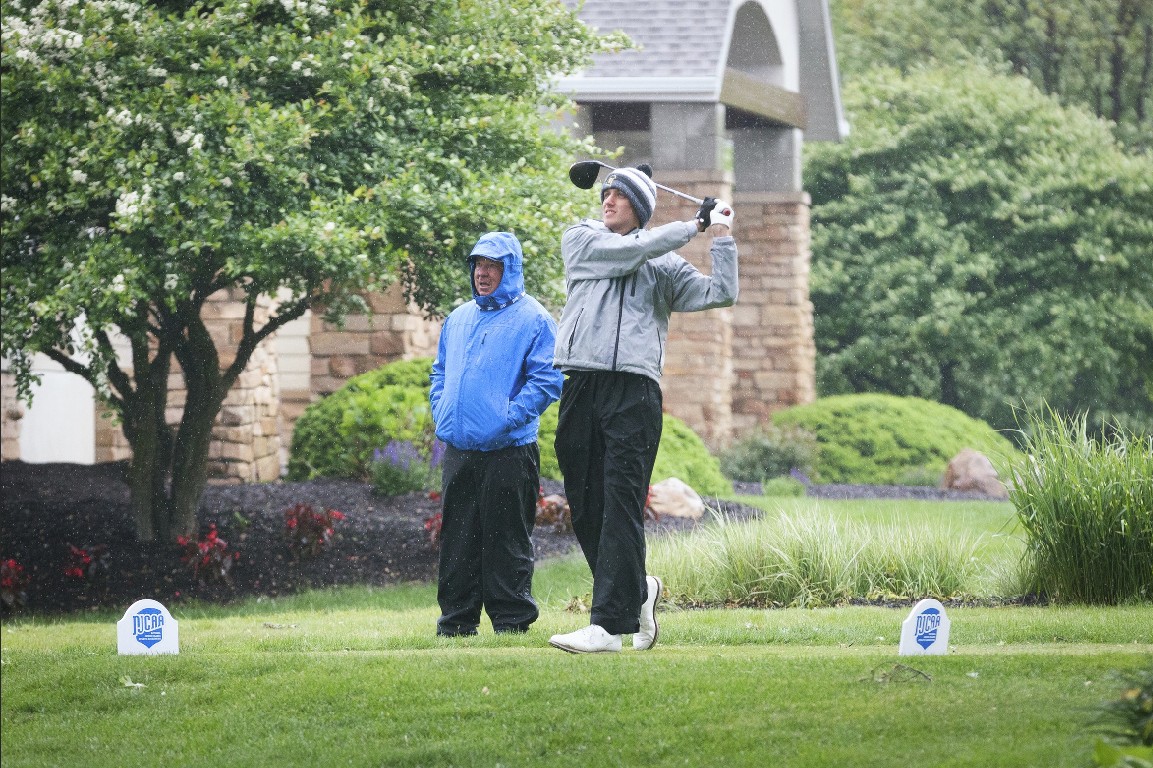 MCC men's golfer teeing off in the rain.